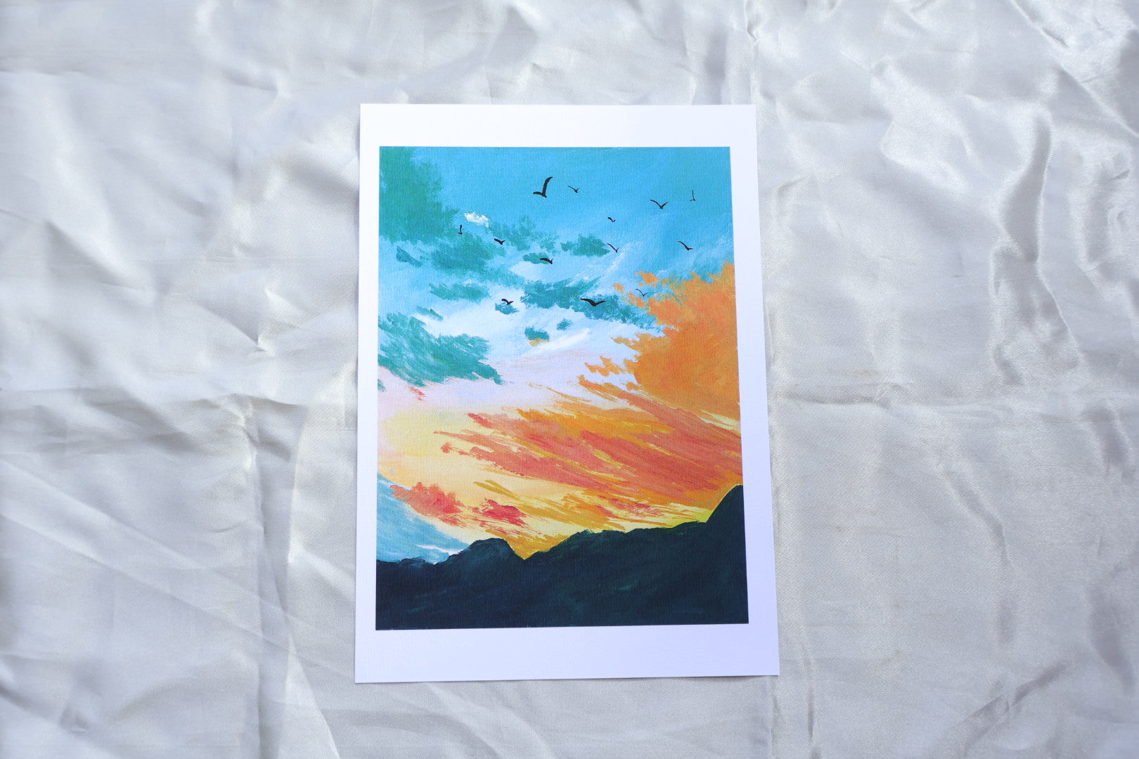 Bluish green sunset orange sky with dark green mountains

