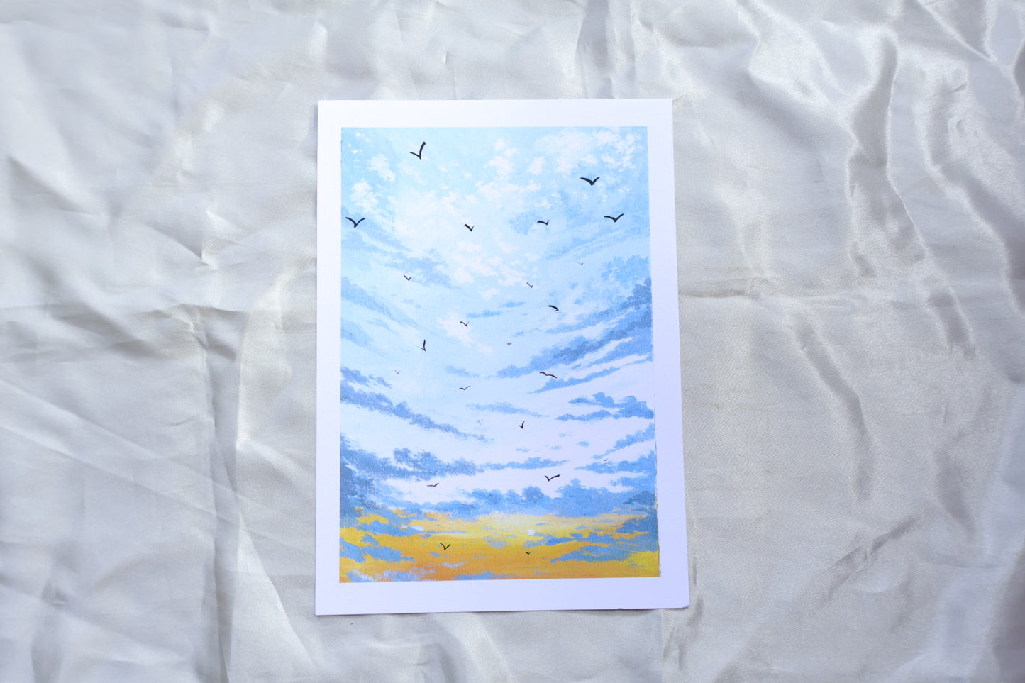 A sunrise scene portraying birds flying towards you, from white clouds at the top, and a gradient towards the bottom, blueish grey clouds, at the background of a bright yellow glow, and small sun in the bottom left.