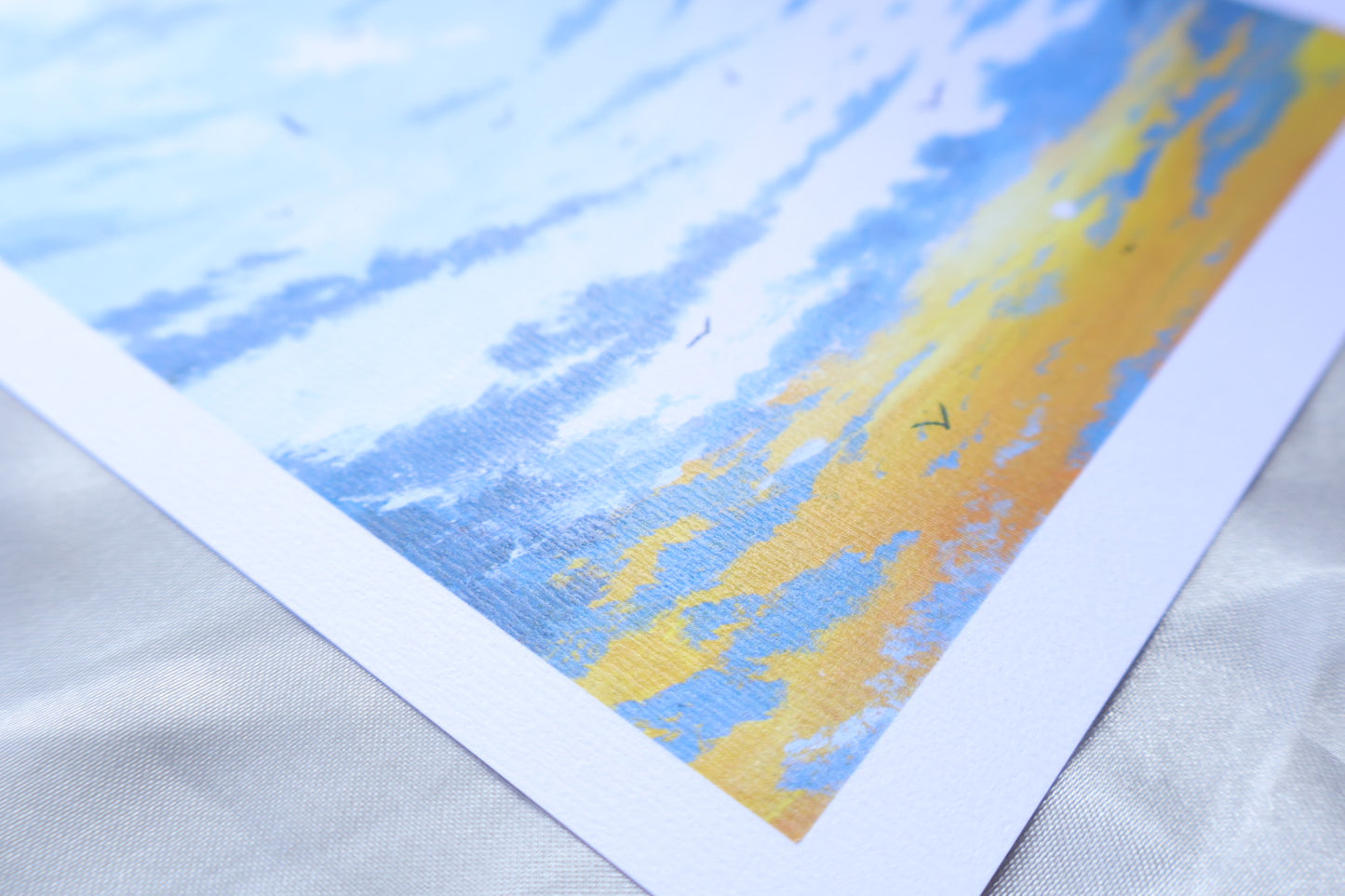 A sunrise scene portraying birds flying towards you, from white clouds at the top, and a gradient towards the bottom, blueish grey clouds, at the background of a bright yellow glow, and small sun in the bottom left.