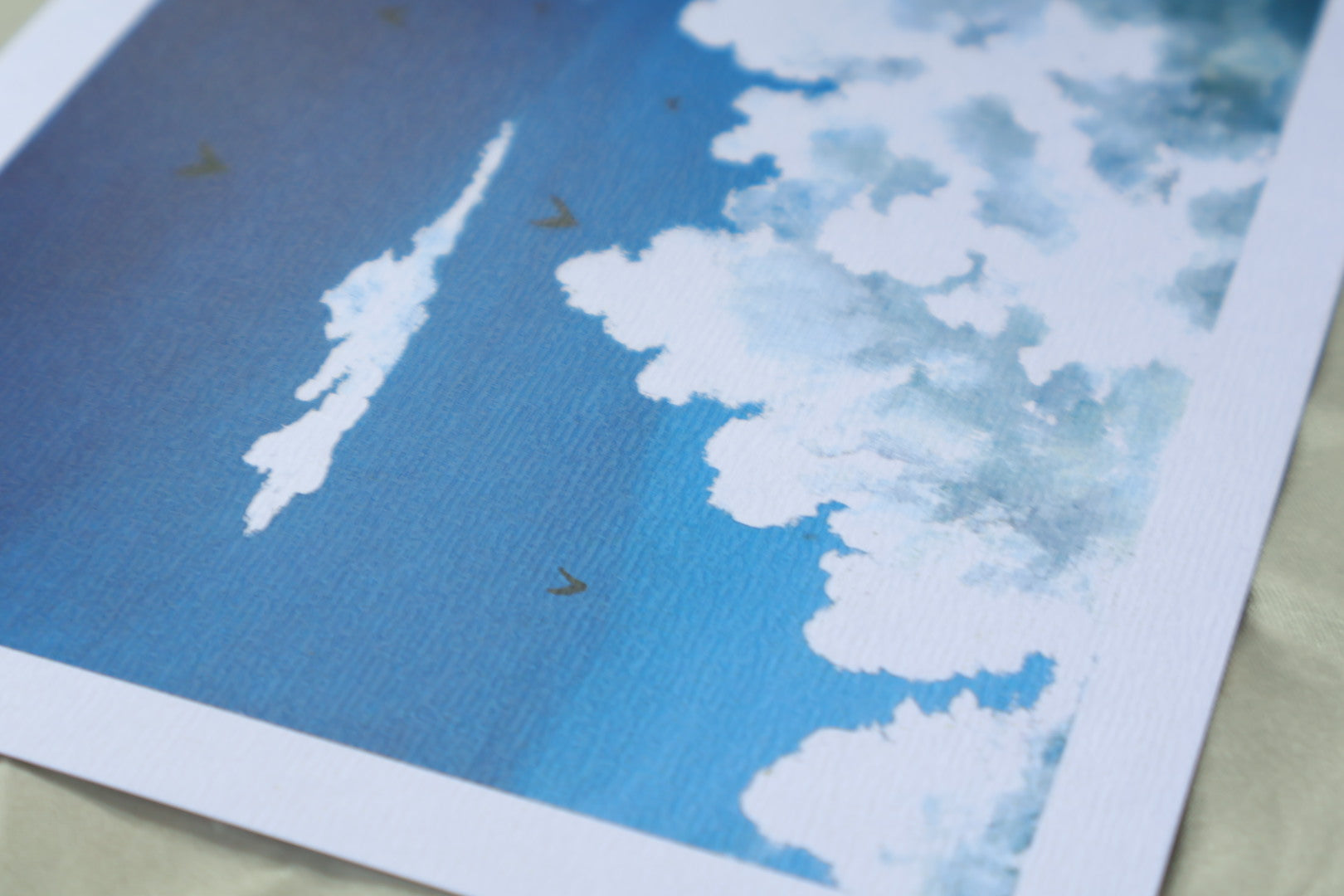 Blue sky with fluffy white clouds and birds on textured paper